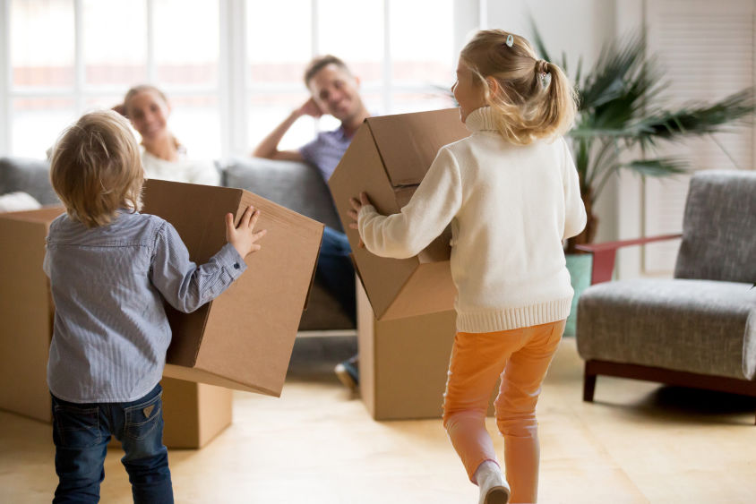 Children running with boxes as their parents watch them